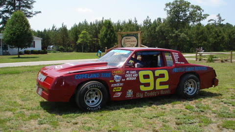 Red number 92 stock car parked on grass at Chiskie Gardens